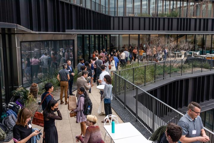 A slightly overhead shot of an outdoor patio where several students, alumni, and faculty members are mingling.